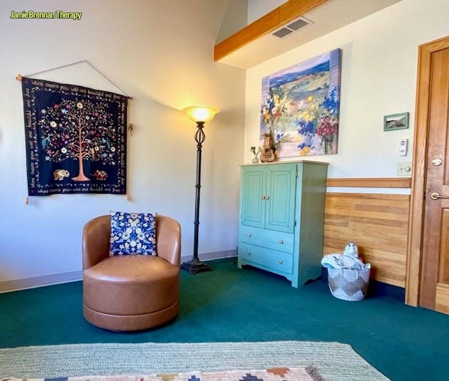 Welcoming counseling office at Jamie Brennan Therapy in Boulder Colorado featuring a comfortable chair, colorful artwork, and warm lighting.